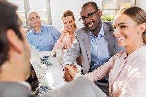 Happy business colleagues shaking hands on a meeting.